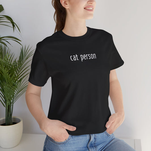 smiling person wearing a black t-shirt with 'cat person' text in white