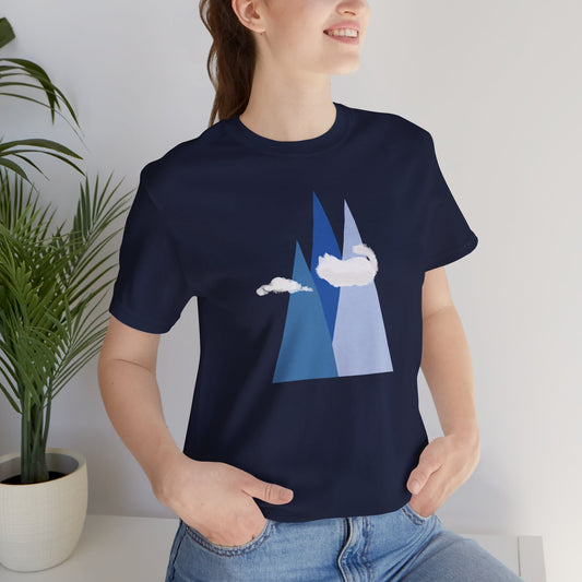 smiling person wearing a navy blue t-shirt with mountain and cat cloud graphic