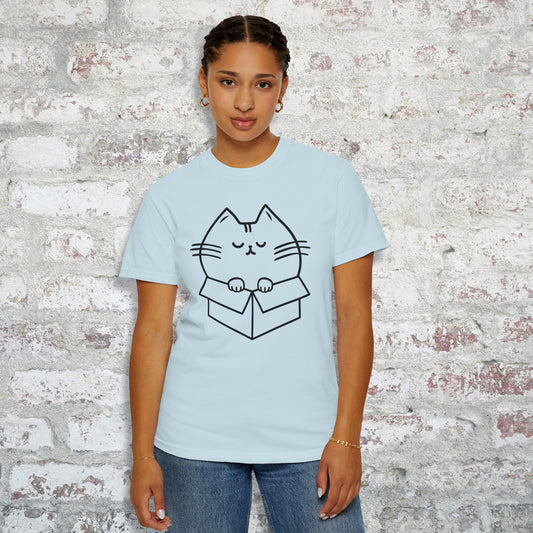 Person wearing a light blue t-shirt with a line drawing design of a chubby cat squeezed into a box