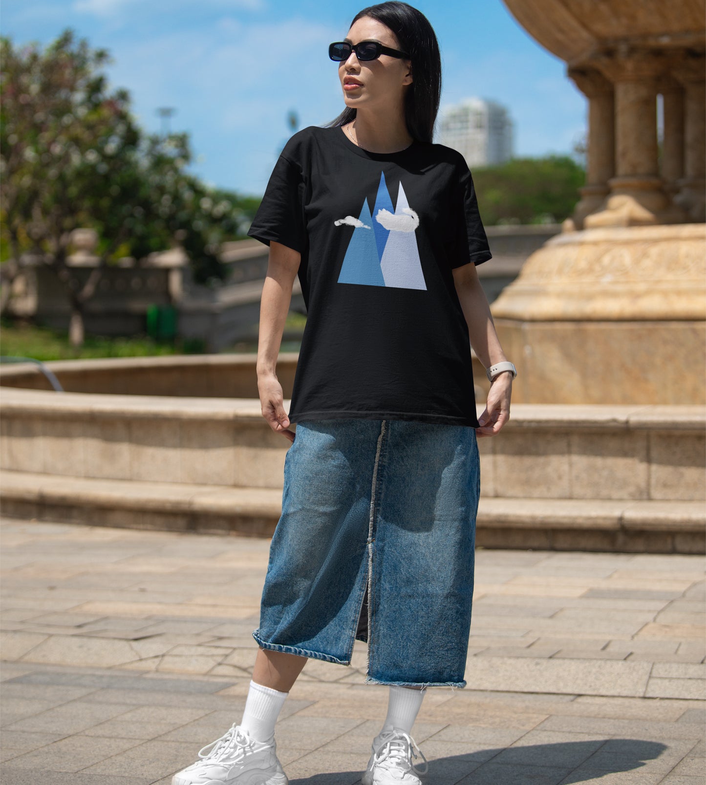 person wearing a black t-shirt with mountain and cat cloud graphic