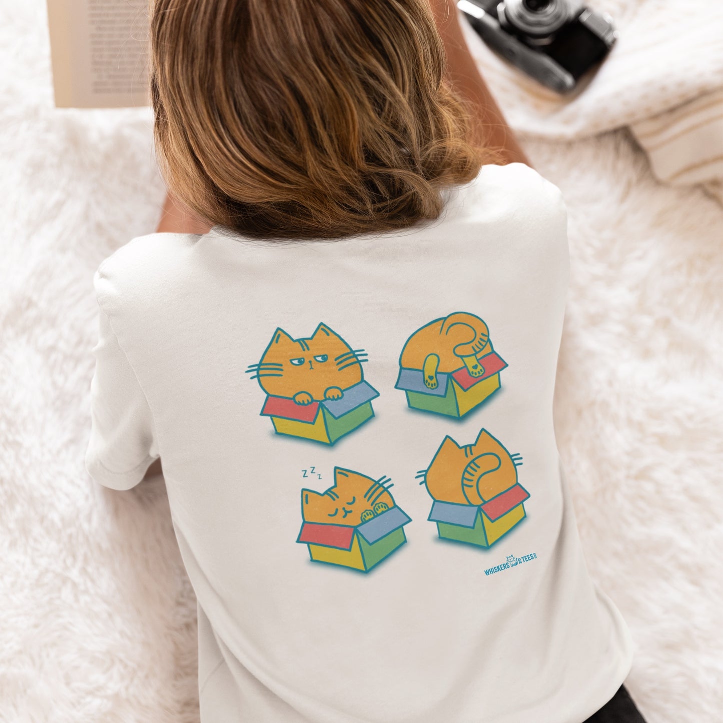 person wearing a white graphic t-shirt with four chubby orange cats, each in its own colorful box on the back of the shirt