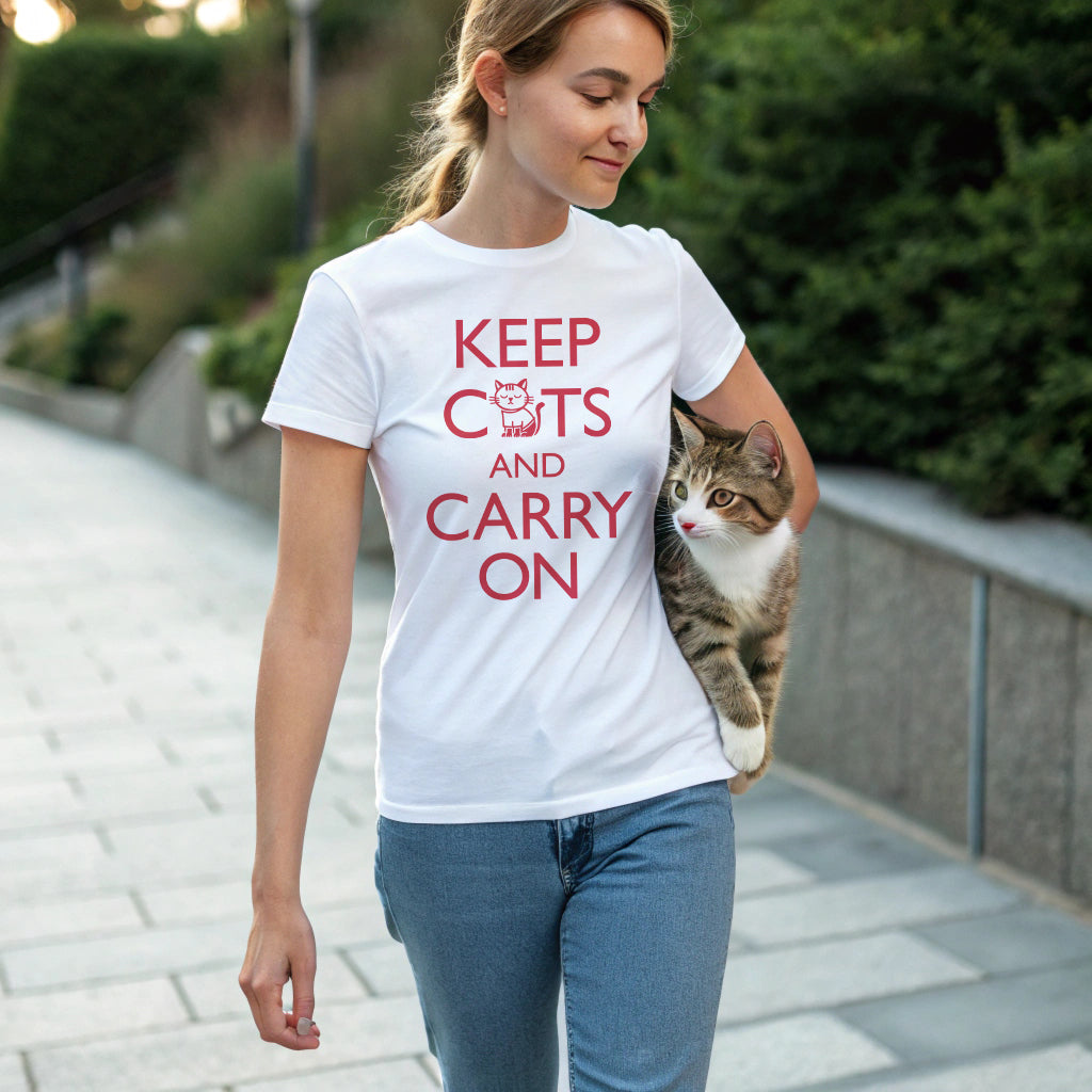 woman carrying a tabby cat wearing a white t-shirt with 'Keep Cats and Carry On' text on the front that incorporates the graphic of a nonchalant cat