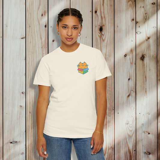 person wearing an ivory graphic t-shirt with chubby orange cat in a color box on the front of the shirt
